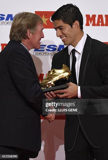 Former Liverpool coach Kenny Daglish shakes hands with Barcelona's Uruguayan forward Luis Suarez after presenting Suarez the 2014 Golden Boot,...