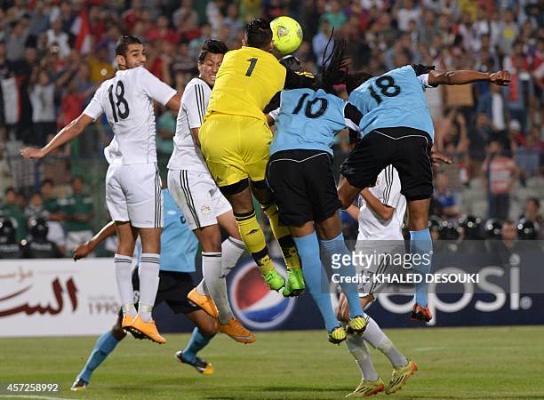 Egypts national team goalkeeper Ahmed El-Shenawy fights for the ball against Botswanas players Kenano Kgetholetsile and Mogogi Gabonamong during...