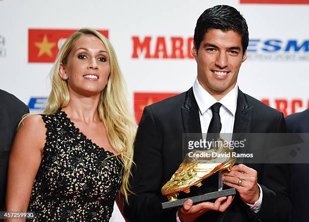 Luis Suarez poses with the Goden Boot Trophy as the best goal scorer in all European Leagues last season with his wife Sofia Balbi on October 15,...