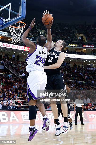 Carl Landry of Sacramento Kings shoots against Mirza Teletovic of Brooklyn Nets during the 2014 NBA Global Games match between the Brooklyn Nets and...