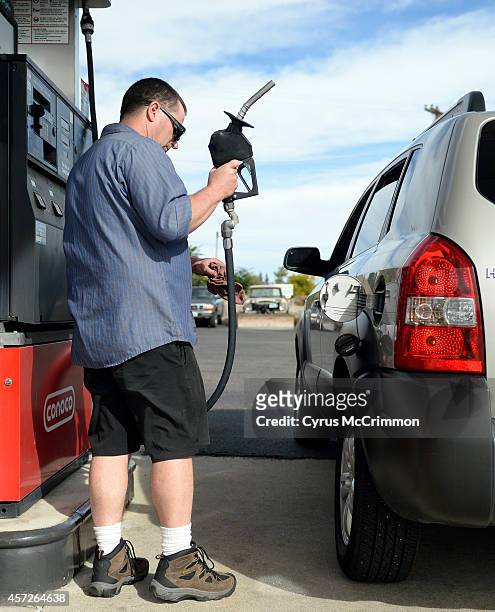 Paul Funk an auto technician at Brad's Conoco, 1075 S. Union Blvd., in Lakewood, CO fills up a customer's car on Wednesday, October 15, 2014. To be...