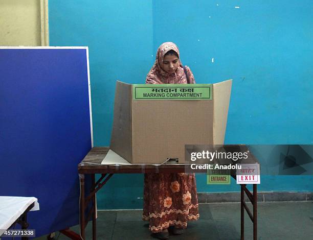 Indian people cast their vote during the Maharashtra state elections at the polling station on October 15, 2014 in Mumbai, India.