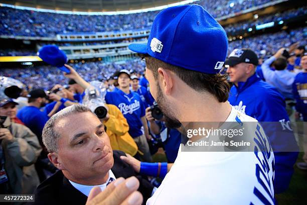 Eric Hosmer of the Kansas City Royals celebrates with General Manager Dayton Moore after their 2 to 1 win over the Baltimore Orioles to sweep the...