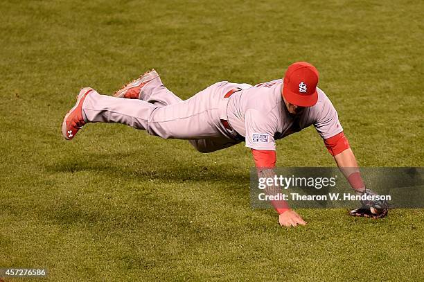 Kolten Wong of the St. Louis Cardinals dives to field a ball hit by Travis Ishikawa of the San Francisco Giants in the fourth inning during Game Four...