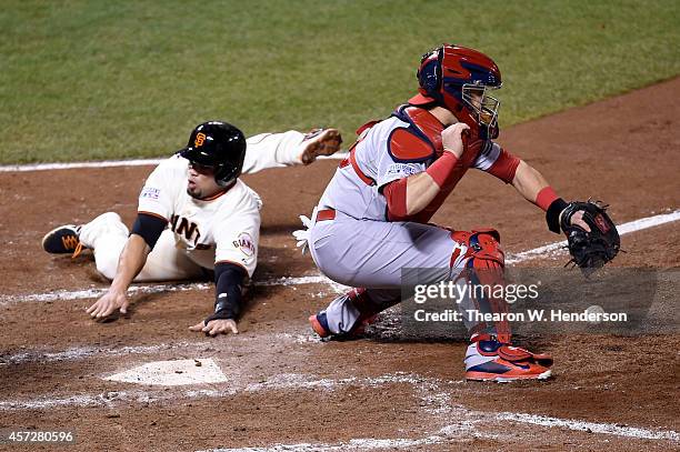 Juan Perez of the San Francisco Giants slides home safely as catcher Tony Cruz of the St. Louis Cardinals is unable to catch the ball in the sixth...