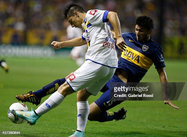 Oscar Ruiz of Deportivo Capiata competes for the ball with Leandro Marín of Boca Juniors during a match between Boca Juniors and Deportivo Capiata as...