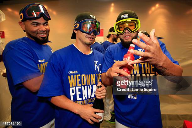 Norichika Aoki of the Kansas City Royals celebrates with teammates Kelvin Herrera and and Francisley Bueno in the locker room after their 2 to 1 win...