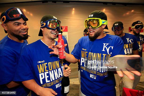 Norichika Aoki of the Kansas City Royals celebrates with teammates Kelvin Herrera and Francisley Bueno in the locker room after their 2 to 1 win over...