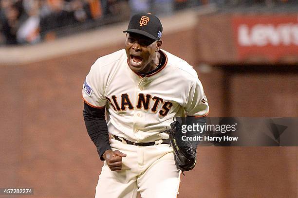 Santiago Casilla of the San Francisco Giants reacts after getting the final out in the ninth inning against the St. Louis Cardinals during Game Four...