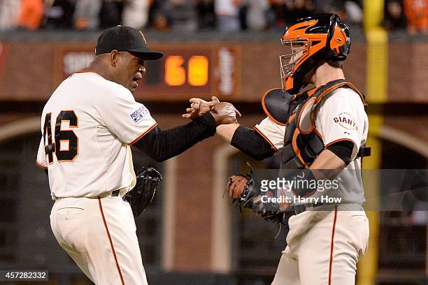 Santiago Casilla and Buster Posey of the San Francisco Giants celebrate after getting the final out in the ninth inning against the St. Louis...