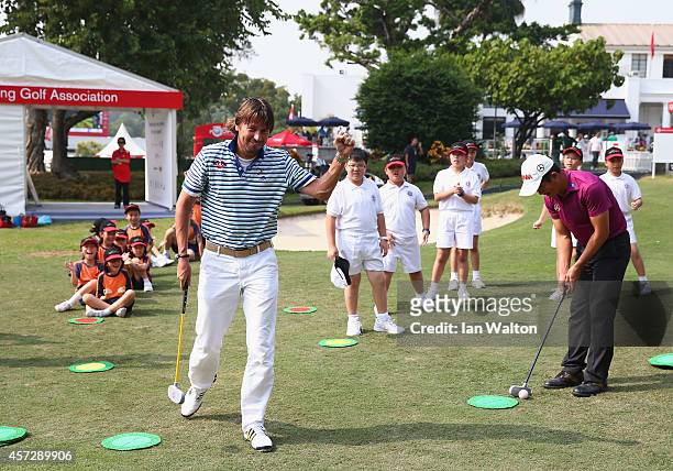 Robert Jan Derksen of The Netherlands and Liang Wen-Chong of China take part in a kids golf clinic during the first round of the 2014 Hong Kong open...