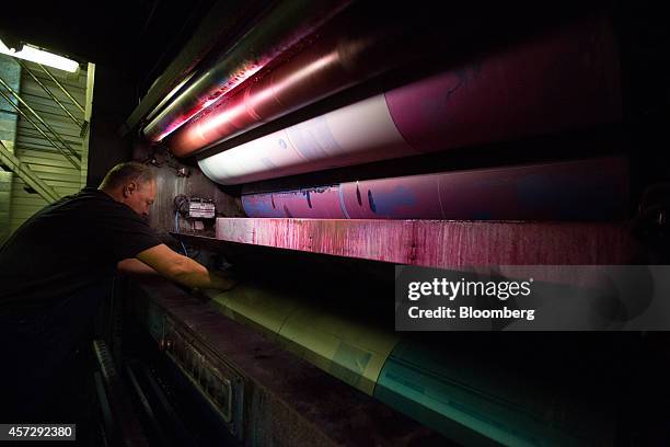 Printer positions an offset lithographic printing plate on the rollers of a press as copies of Vedomosti, a daily business newspaper owned by the...