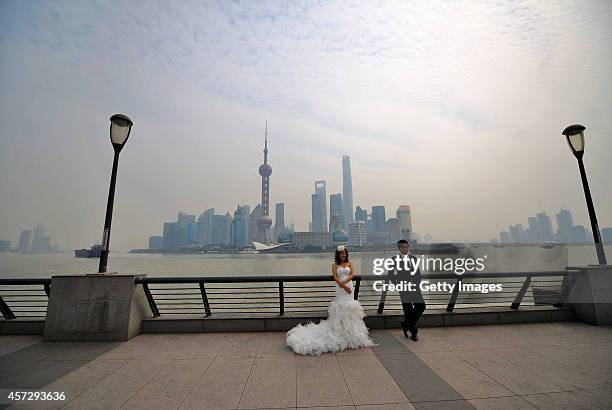 Pair of young lovers take wedding photos in smog at The Bund on October 16, 2014 in Shanghai, China. A report from Shanghai Environmental Monitoring...