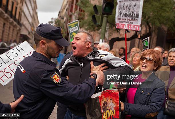 Protester is held back by a policeman at Madrid's High Court where Rodrigo Rato, former chairman of rescued bank Bankia and former head of the...