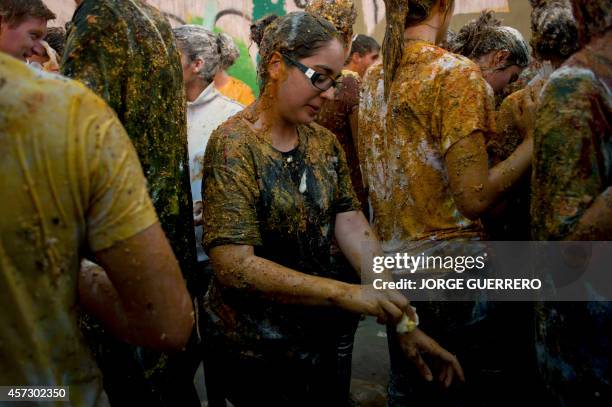 Freshman year medical students covered with food stuffs stand during a faculty of medicine hazing at the University of Granada, in Granada on October...