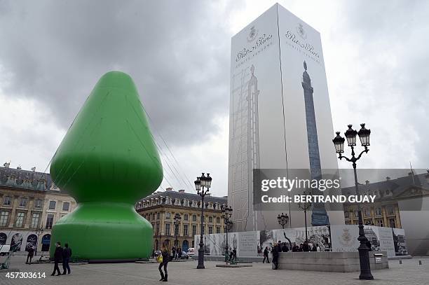 Picture taken on October 15, 2014 shows a 25 meters high inflatable sculpture by US artist Paul McCarthy on the Place Vendome in Paris, as part of...