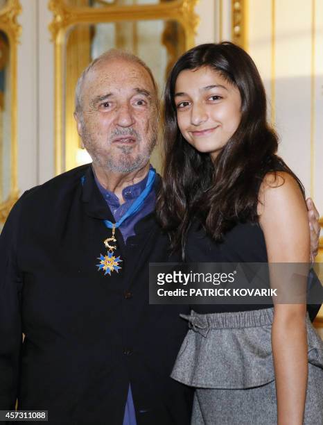 French writer and screenwriter Jean-Claude Carriere poses with his daughter Kiara after being awarded the medal of Commander of the National Order of...