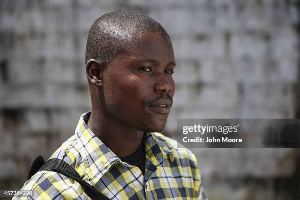 Moses Lansanah stands at the Doctors Without Borders , Ebola treatment center after meeting with fellow survivors on October 16, 2014 in Paynesville,...