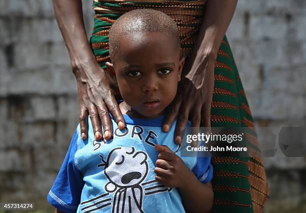 Ebola survivor James Mulbah stands with his mother, Tamah Mulbah who also recovered from Ebola in the low-risk section of the Doctors Without Borders...