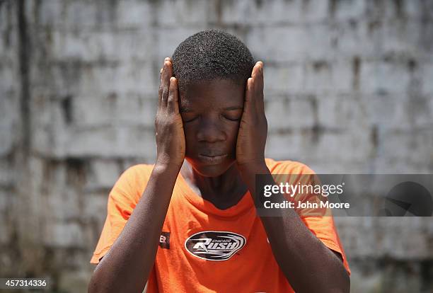 Ebola survivor Jeremra Cooper wipes his face from the heat while in the low-risk section of the Doctors Without Borders , Ebola treatment center on...