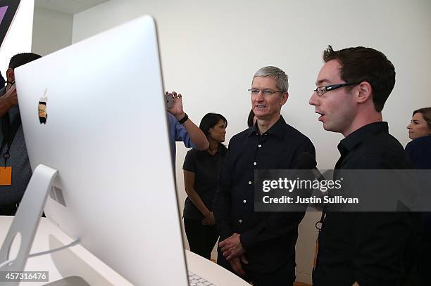 Apple CEO Tim Cook looks at the new 27 inch iMac with 5K retina display during an Apple special event on October 16, 2014 in Cupertino, California....