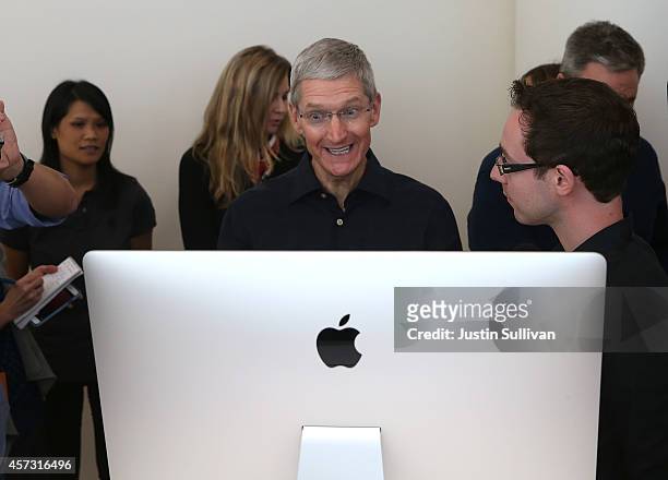 Apple CEO Tim Cook looks at the new 27 inch iMac with 5K retina display during an Apple special event on October 16, 2014 in Cupertino, California....