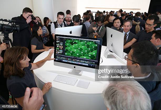 Attendees inspect the new 27 inch iMac with 5K Retina display during an Apple special event on October 16, 2014 in Cupertino, California. Apple...