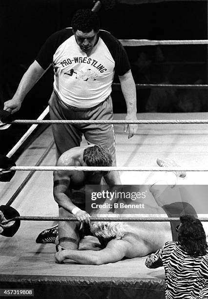 French professional wrestler and actor Andre the Giant , in the ring as a special guest referee, looks on as Rowdy Roddy Piper grabs Adrian Adonis by...