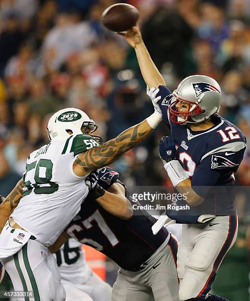 Jason Babin of the New York Jets tackles Tom Brady of the New England Patriots during the second quarter at Gillette Stadium on October 16, 2014 in...