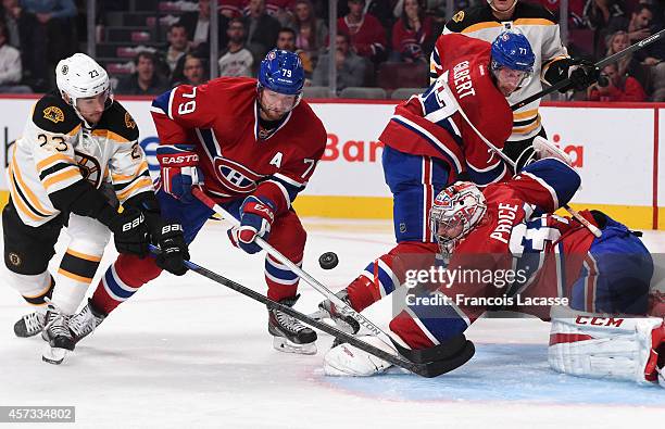 Carey Price and Andrei Markov of the Montreal Canadiens fight for the puck with Chris Kelly of the Boston Bruins in the NHL game at the Bell Centre...