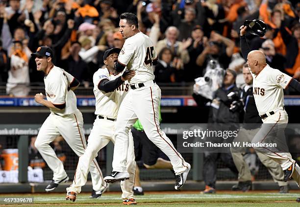 Travis Ishikawa of the San Francisco Giants celebrates with Santiago Casilla after Ishikawa hits a three-run walk-off home run to defeat the St....