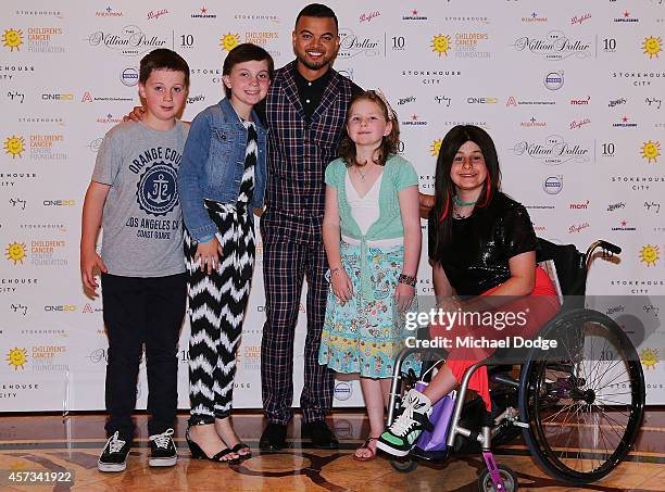 Guy Sebastian poses with kids that are in remission from cancer at the 10th anniversary celebration of The Million Dollar Lunch at the Park Hyatt on...