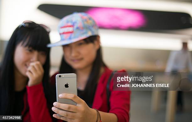 Chinese girls check out the iPhone 6 in an Apple store in Shanghai on October 17, 2014. Apple began selling its latest iPhone in China, nearly a...