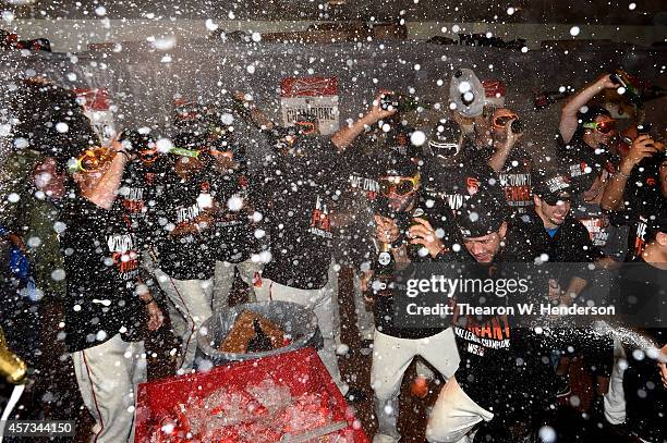 The San Francisco Giants celebrate in the locker room after defeating the St. Louis Cardinals 6-3 during Game Five of the National League...