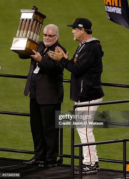 General manager Brian Sabean and manager Bruce Bochy of the San Francisco Giants hold up the Warren C. Giles Trophy after the Giants defeat the St....