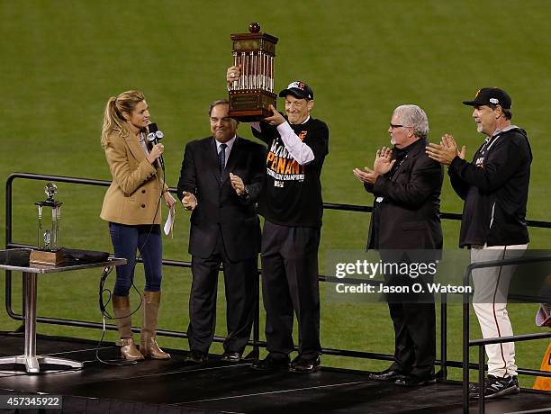 Owner Larry Baer, general manager Brian Sabean and manager Bruce Bochy of the San Francisco Giants hold up the Warren C. Giles Trophy after the...