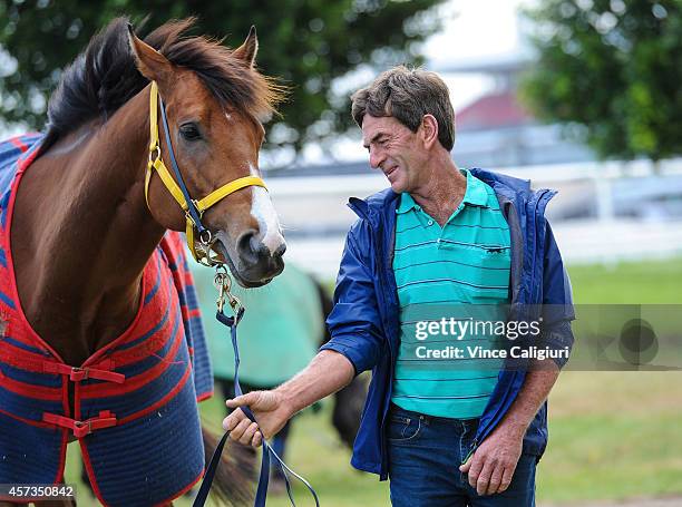 Trainer Phillip Atkins poses with In Cahoots at Flemington Racecourse on October 16, 2014 in Melbourne, Australia.