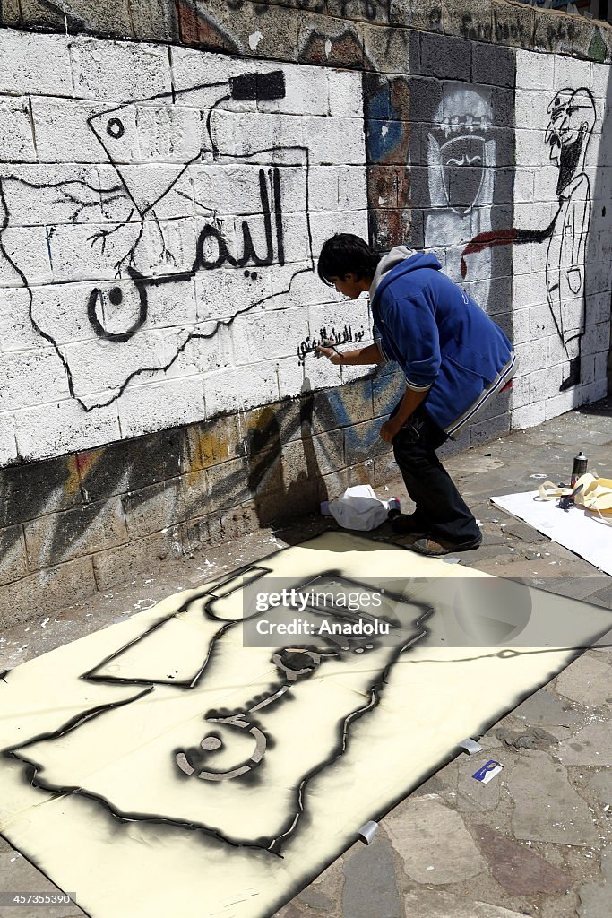 Graffiti artists paint armed men pictures on walls in Yemen