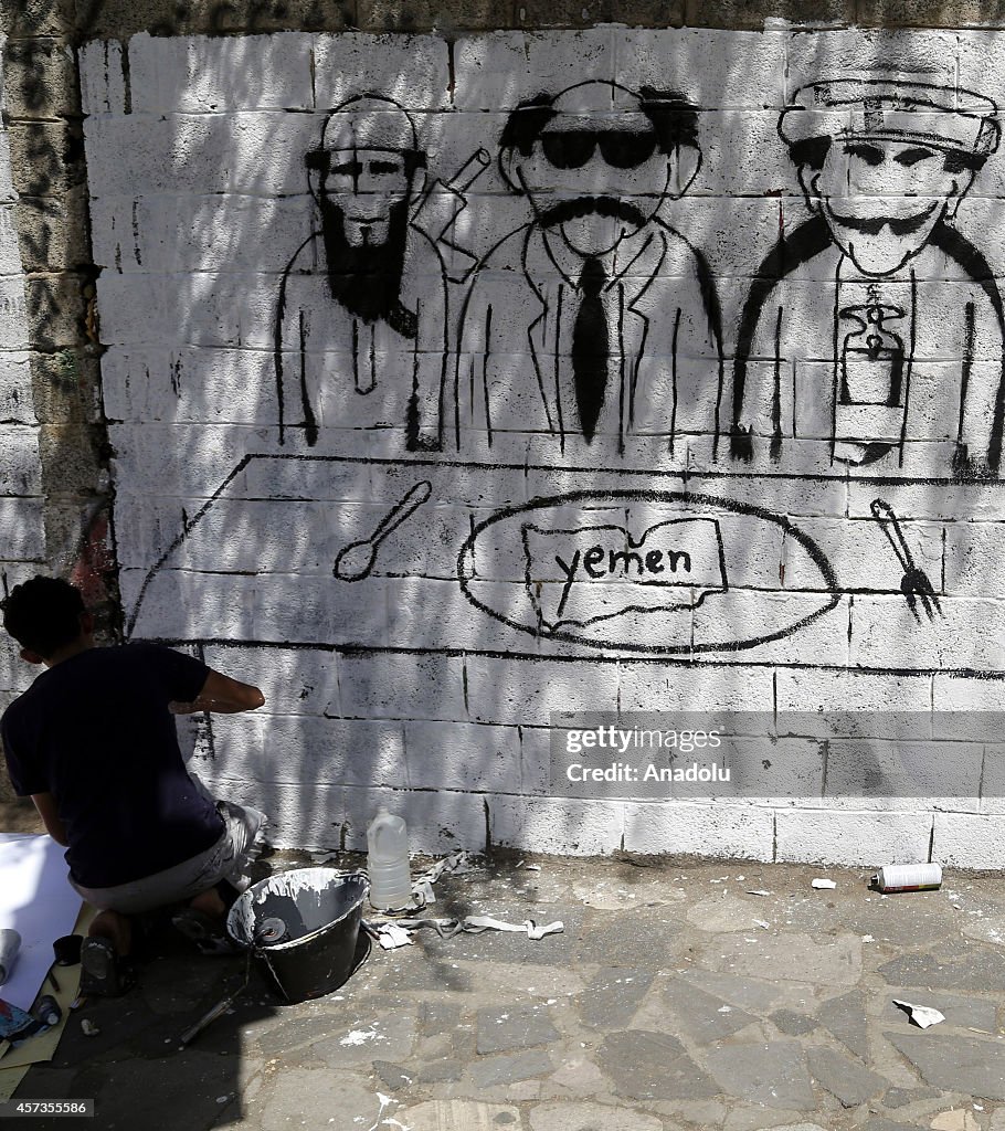 Graffiti artists paint armed men pictures on walls in Yemen