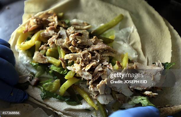 Chef wraps a chicken Shawarma sandwich at a restaurant in Jounieh, north of the Lebanese capital Beirut, on October 17, 2014. Shawarma is probably...