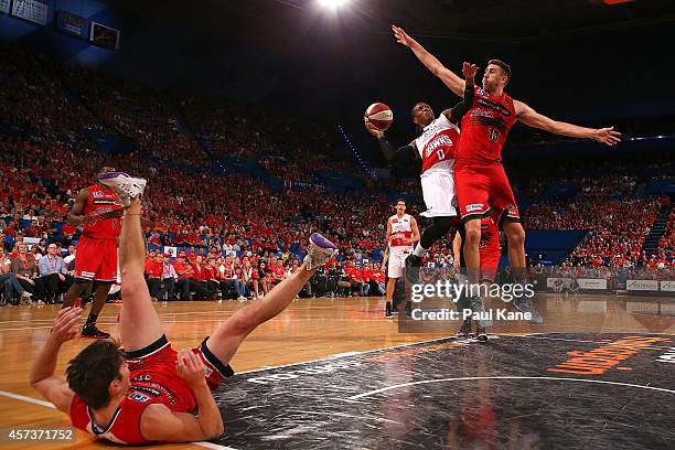 Jahil Carson of the Hawks drives to the basket against Damian Martin and Tom Jervis of the Wildcats during the round two NBL match between the Perth...