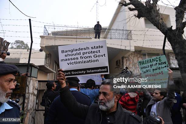 Pakistani civil society activists hold up placards during a protest against the execution of Bangladeshi Islamist leader Abdul Quader Molla, outside...