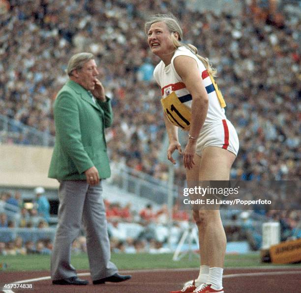 Gold medallist Mary Peters of Great Britain looking at the scoreboard for her 200 metres time after the final discipline of the Women's pentathlon...