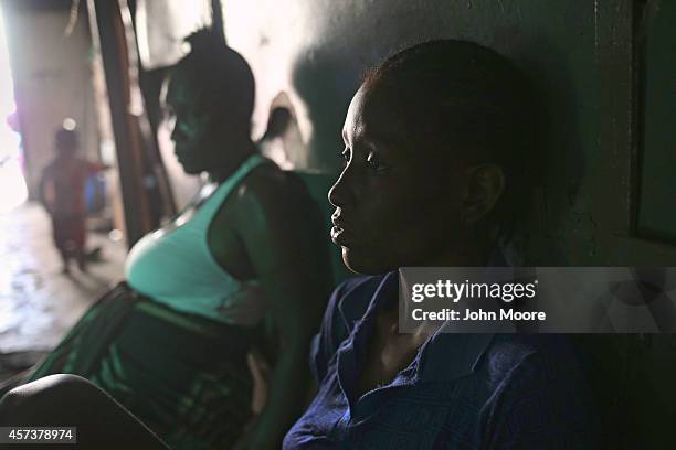 Comfort Swen , and her daughter Jessica Sompon both with fever, await health workers to escort them and Sompon's daughter Benson, 2 months, to an...