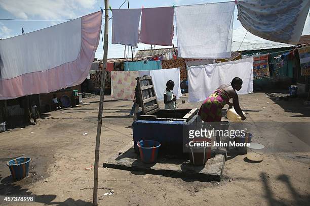 People draw water in the West Point neighborhood, where many people have died from Ebola on October 17, 2014 in Monrovia, Liberia. The World Health...