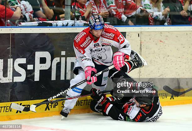 John Tripp of Koelner Haie and Petr Pohl of Eisbaeren Berlin battle for the puck during the DEL Ice Hockey match between Koelner Haie and Eisbaeren...