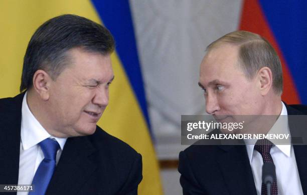 Ukrainian President Viktor Yanukovych winks at Russia's President Vladimir Putin during a signing ceremony at the Kremlin in Moscow, on December 17,...