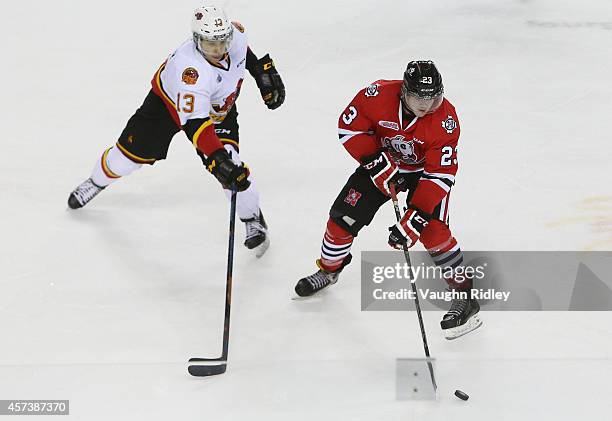 Johnny Corneil of the Niagara Ice Dogs and Stephen Harper of the Belleville Bulls battle for the puck during an OHL game at the Meridian Centre on...