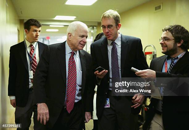 Sen. John McCain talks to reporters as he arrives for a vote December 17, 2013 on Capitol Hill in Washington, DC. The Senate has passed a cloture...