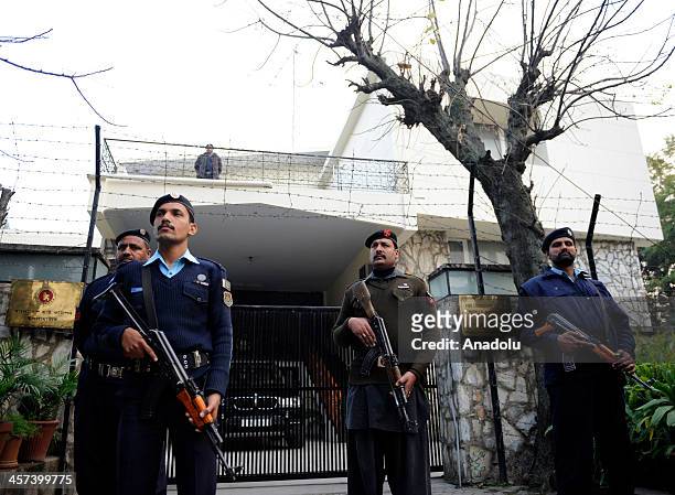 Pakistani security officials stand guard outside the Bangladesh high commission as members of the Civil Society Islamabad stage protest to condemn...